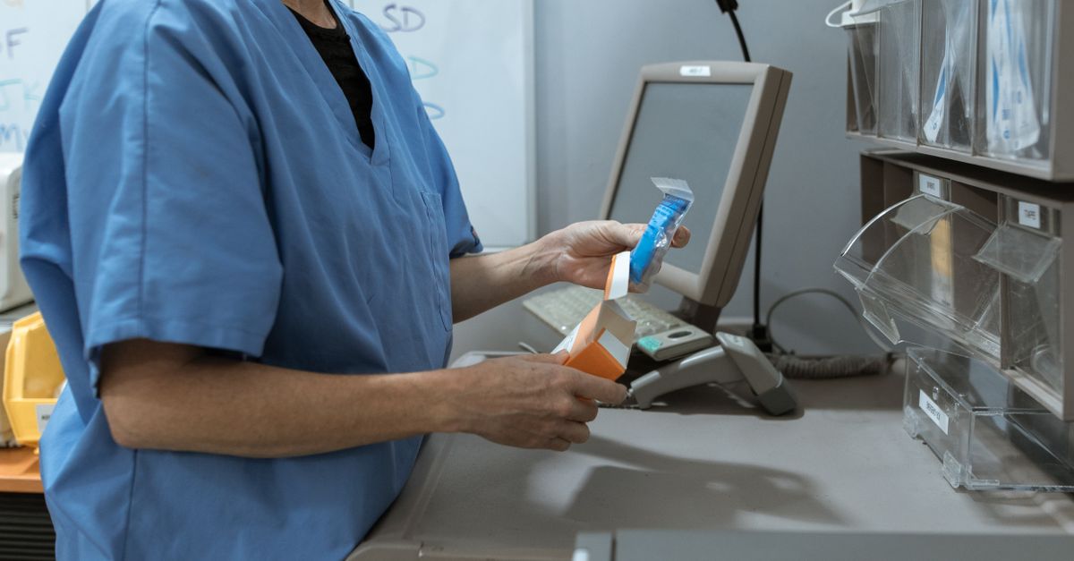 Professionnelle de santé rangeant des médicaments dans une pharmacie